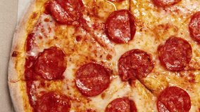Delicious Italian pepperoni pizzas delivery filmed directly from above in flat lay style on table.Fresh fast food delivered in cardboard box for dinner.Hot pizza delivered from fastfood restaurant