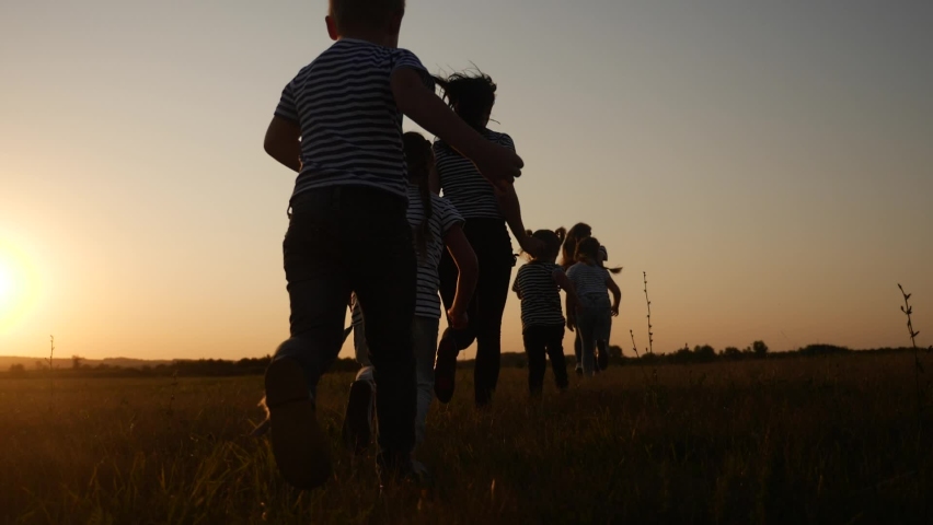 children happy family kid together run in the park at sunset silhouette. people in the park concept. mom daughter and son joyful run. happy family and little baby child summer fun kid dream concept