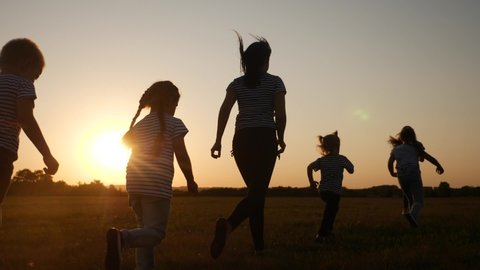 children happy family kid together run in the park at sunset silhouette. people in the park concept. mom daughter and son joyful run. happy family and little baby child summer fun kid dream concept