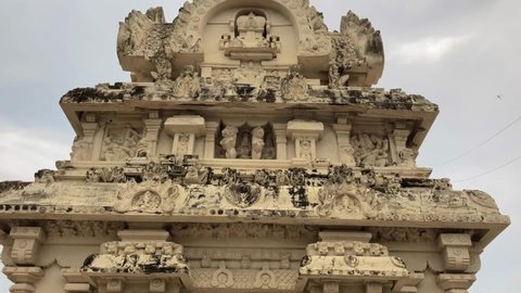 Beautiful sandstone ancient historical carvings of God, animal sculpture on the walls of Kanchi Kailasanathar temple in Kanchipuram, Tamilnadu. View of historic temple tower with carved sculptures.