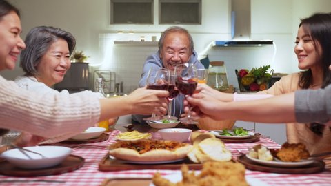 Happy family time and relationship, Asian big family having party eating food and toasting wine glass together at home. People is happy and enjoy eating meal on dining table at home.