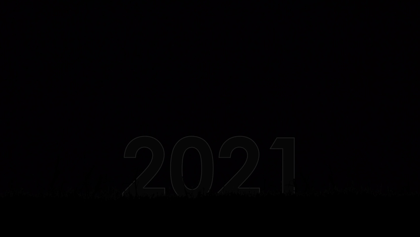 Red text 2021 with particles and sparks with colored  fireworks on background. New year celebration. 