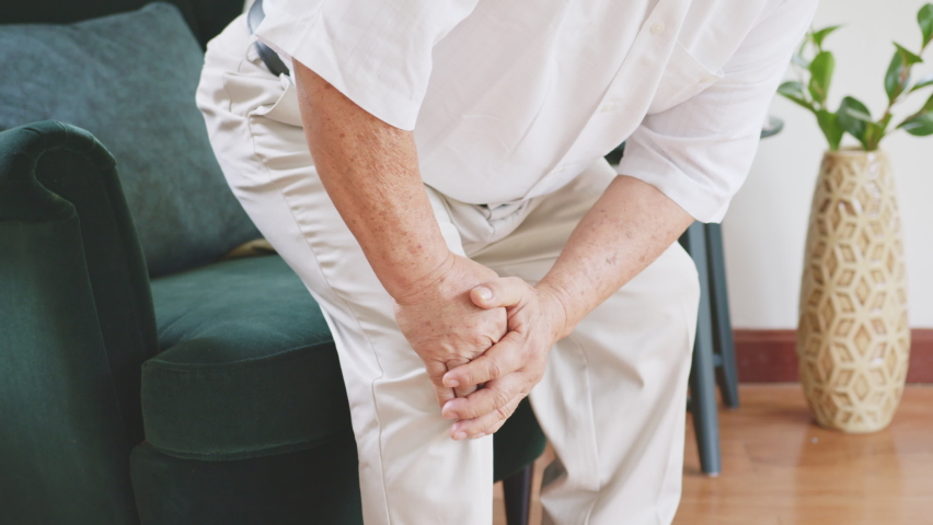 Closeup old Asian senior man feel pain, ache, hurt at knee while standing and sitting at home, osteoarthritis concept | Shutterstock HD Video #1061995786
