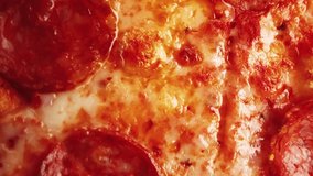 Delicious Italian pepperoni pizza baked in oven with mozzarella cheese and spice.Filmed in flat lay style directly from above.Video clip of tasty natural pizzaeria fastfood cooked in Italy