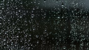SLOW MOTION, MACRO, DOF: Raindrop trickles down a wet window during a rainstorm. clear raindrops accumulate on the windowpane and trickle down the glass. Droplets of fresh rainwater on a window. - Powered by Shutterstock - Get 15% off with code: PIKWIZARD15