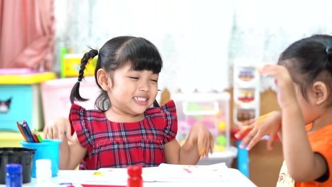 Asian cute kid girl showing hand with colorful painting. creative girl with fun