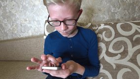 Caucasian child indoor using cell phone, win  or success concept