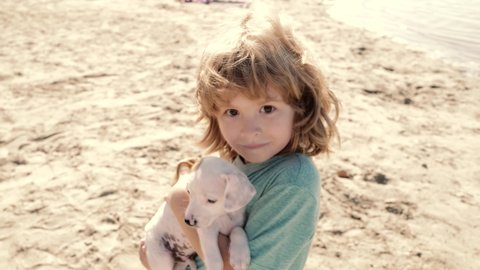 Portrait child boy with a pet. Cute child and puppy playing outside. Happy child and dog hug her with tenderness smiling. Best friends child and puppy rest and have fun on vacation.