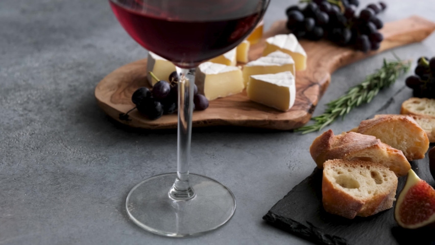 Cheese plate with fruits, camemebert cheese and glass of red wine. Italian appetizer starter plate | Shutterstock HD Video #1062021607