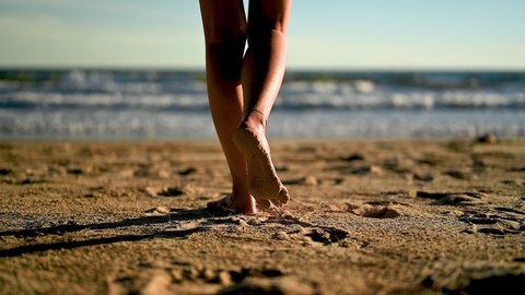 Woman near the ocean.running on the beach. Footsteps in the sand. Summer on the beach. Holiday,travel and vacation concept. 