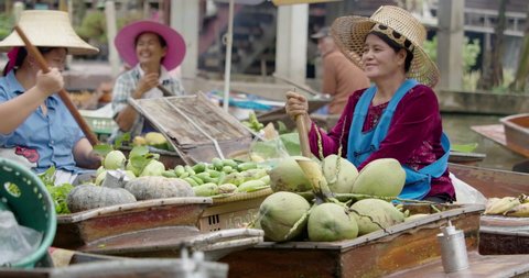 Ayutthaya Bangkok Thailand traditional holiday floating market visitor shop on river selling farmer food and fruit vegetable colourful flowers and clothes on the wooden boat in the morning