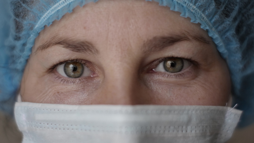 Sad Sick, Overworked Serious Female Health Care Worker Looking at Camera. Portrait Close Up Doctor Nurse Wearing Protective Mask, Protection Against Contagious Corona Virus Disease COVID-19. | Shutterstock HD Video #1062024508
