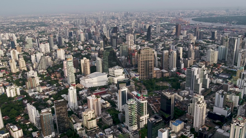 Bangkok, Thailand, flies low between skyscrapers above Wattana District to Makkasan District with city views. Royalty-Free Stock Footage #1062024520
