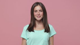 Smiling beautiful charming brunette young woman 20s years old wearing casual blue t-shirt posing isolated on pink colour background in studio. People sincere emotions lifestyle concept. Looking camera - Powered by Shutterstock - Get 15% off with code: PIKWIZARD15