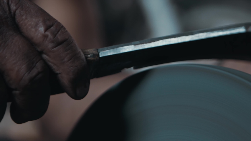 Close up of a knife sharpened on rotating machine, hot sparks flying slow motion Royalty-Free Stock Footage #1062031255