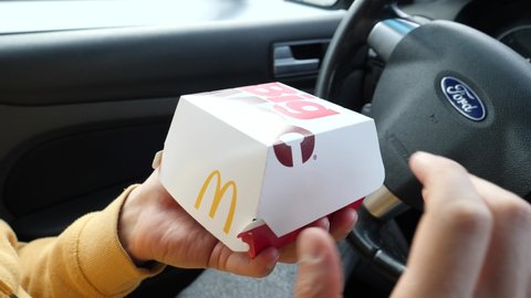WROCLAW, POLAND - NOVEMBER 05, 2020: A Man eat a Big Mac Burger from McDonald's inside a Car