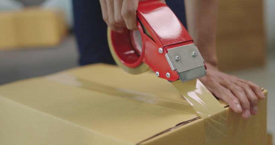 Close Up Shot Asian Female Worker Using Tape Closing Cardboard Box For Deliver To Customer, Slow motion  Royalty-Free Stock Footage #1062039823