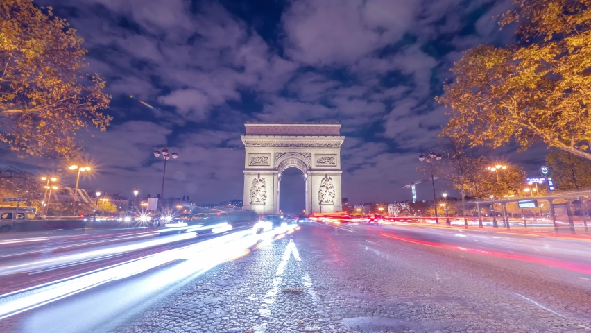 4K Timelapse of traffic at Arc de Triomph at night in an autumn winter day. This historical monument overlooks the avenue des champs élysées in the heart of Paris, French capital.  | Shutterstock HD Video #1062043633