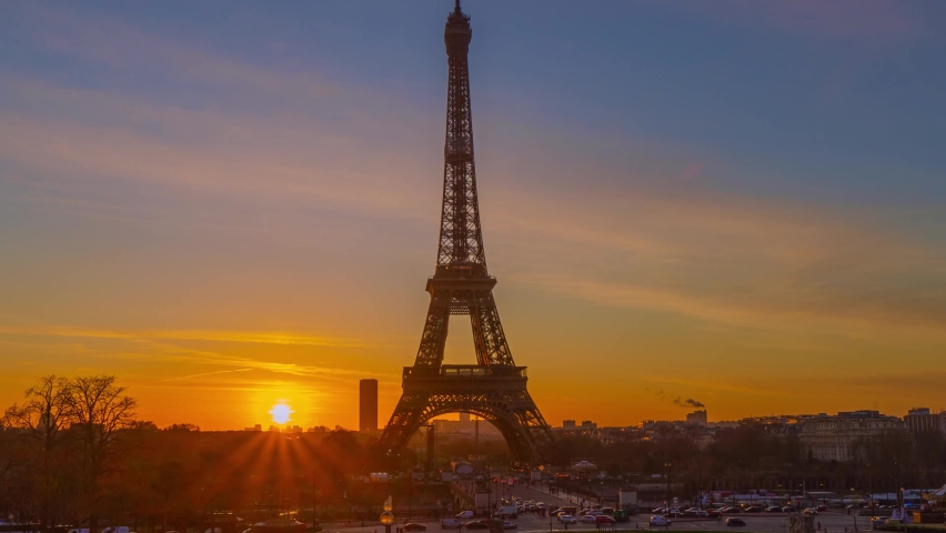 4K timelapse of Paris at sunrise with the Eiffel Tower at the Trocadero gardens and the traffic,the most famous landmark in Paris,France.Golden hour in an autumn winter sunny day in 