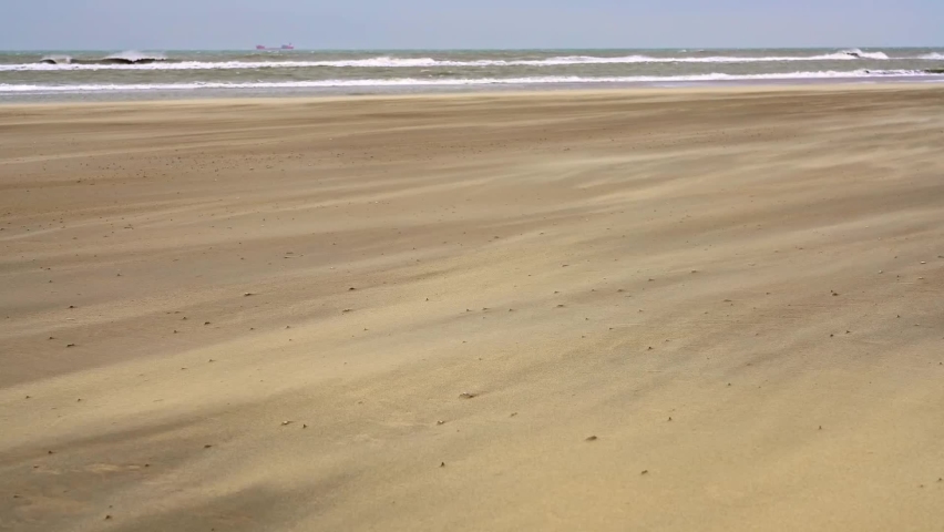 Sand blown by wind in The Hague, Netherlands. Rolling waves on North Sea coast