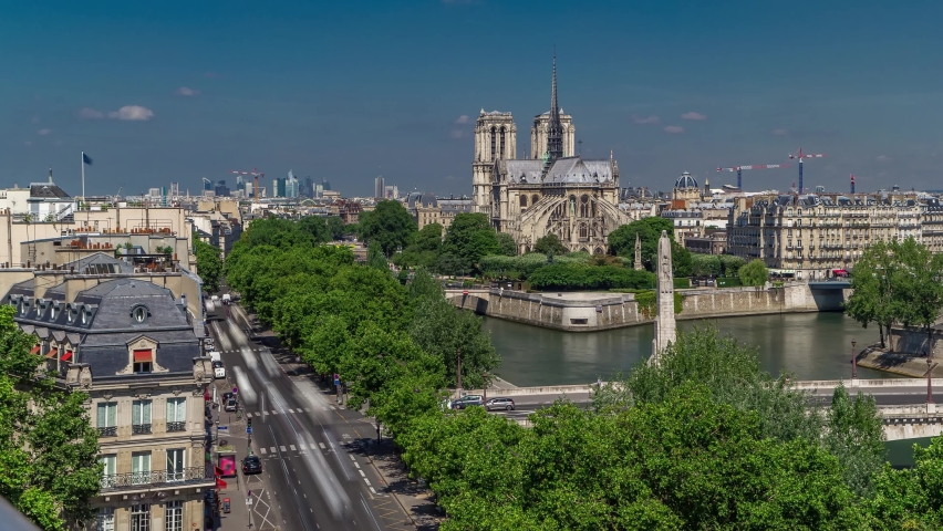Paris Panorama with Cite Island and Cathedral Notre Dame de Paris on the background timelapse from the Arab World Institute observation deck. Top view. Green trees, Seine river, Blue cloudy sky at