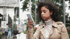 Black young girl using smart phone voice recognition, dictates thoughts, voice dialing message at evening, african american student in cafe, audio ai speech, generation z lifestyle