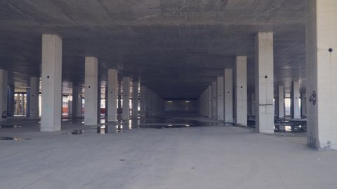 Empty, abandoned construction site with concrete pillars, interior.