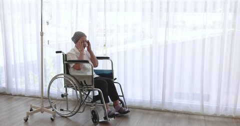 Old Asian woman on a wheel chair and suffering from terrible headache, Disease.