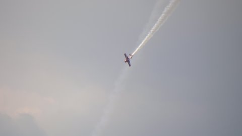 A small plane during an aerobatic simulation: plane engine failure, white smoke coming out from the engine as the plane crashes