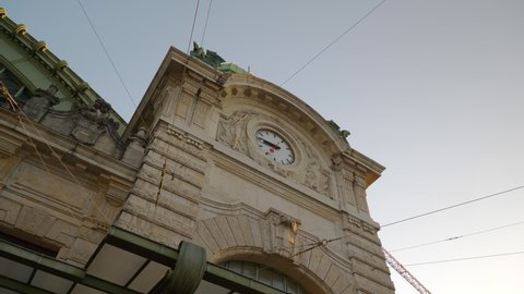 sunset time basel city center train station front facade clock tower top slow motion panorama 4k switzerland