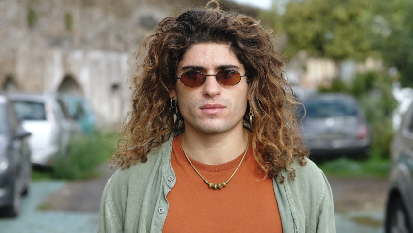 confidence, youth - young man in the street looking at camera and smiling