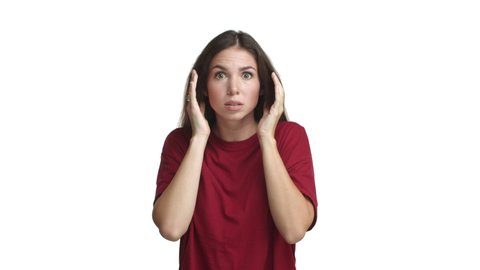 Young attractive woman in red t-shirt looking ambushed and scared, gasping and screaming horrified, standing frightened against white background