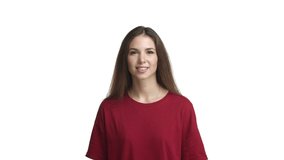 Video of beautiful happy woman in red t-shirt, rejoicing, jumping from happiness and smiling, standing over white background