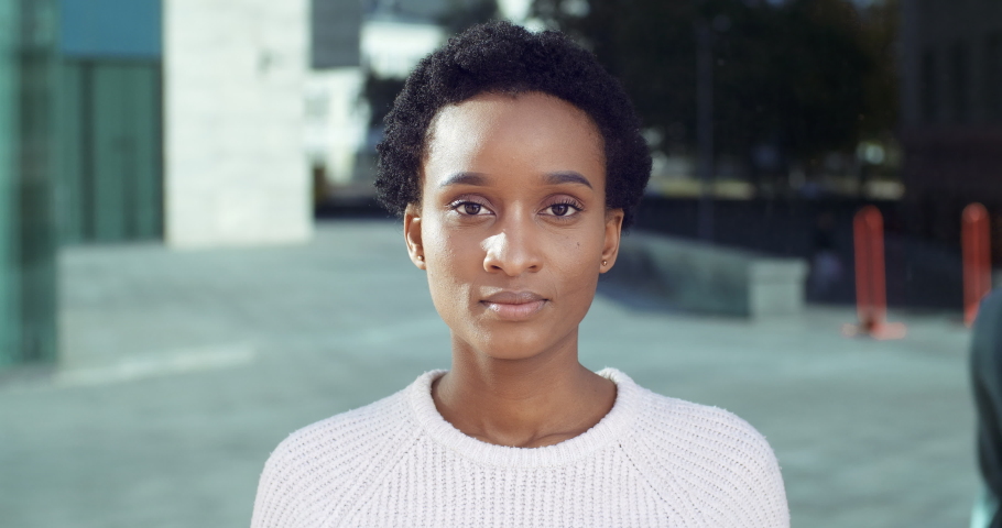 Outdoors portrait of puzzled upset unaware emotional african woman girl shrugs shoulders and looked doubtful at camera being uncertain doesnt know what to answer isolated at city background, close up Royalty-Free Stock Footage #1062066946