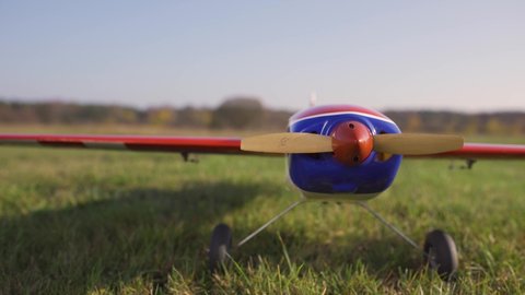 Starting the engine of radio-controlled aircraft, RC plane on grass, camera slider footage, footage of RC aircraft.
