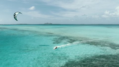 aerial view Kitesurfer speeding with kite in clear crystal water, from drone in Los Roques venezuela Caribbean sea Fantastic landscape Moving aerial view.m