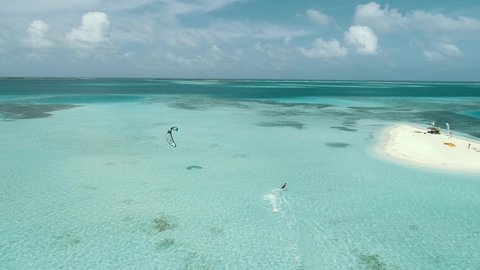 aerial view Kitesurfer speeding with kite in clear crystal water, from drone in Los Roques venezuela Caribbean sea Fantastic landscape Moving aerial view