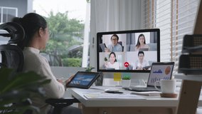 Slow zoom in business woman talking about sale report in video conference.Asian team using laptop and tablet online meeting in video call.Working from home, Working remotely and Self isolation at home
