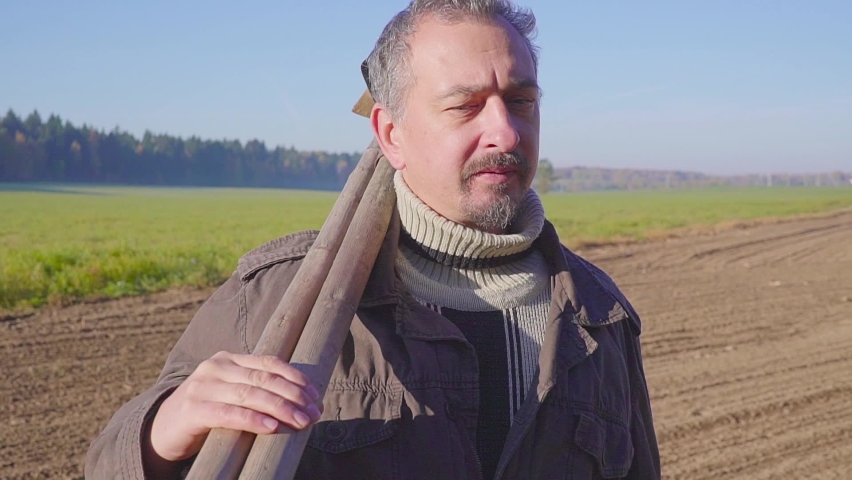handsome farm worker with beard with farm tools protrait