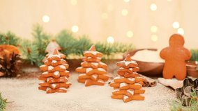 Christmas gingerbread in the shape of a Christmas tree and a star is sprinkled with powdered sugar against the light of bokeh garlands. soft focus on gingerbread, sugar levitation.