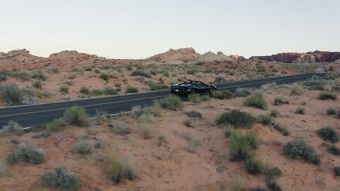 Nevada / United States - 05 25 2019: Black Ferrari convertible driving along on a highway in the Valley of Fire