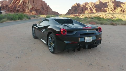 Nevada / United States - 05 24 2019: Male driver opening the roof on a black Ferrari 488 convertible in the Valley of Fire