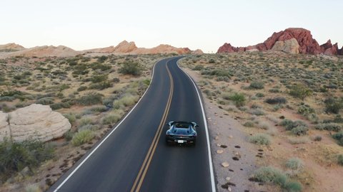 Nevada / United States - 05 24 2019: Black Ferrari sports car speeding along a highway in the Valley of Fire