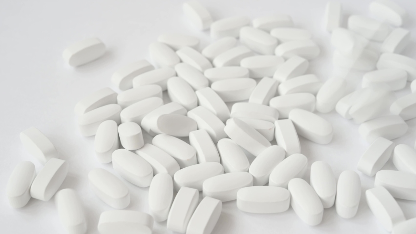 White pills tablets falling down on bright pure surface | Shutterstock HD Video #1062098272