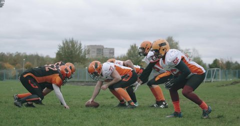 American football, football players in the game, the player catches the ball and falls to the ground, battle between players in protective gear, 4k 50fps.