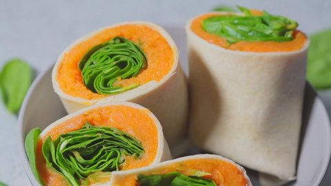 Vegan tortilla wraps with sweet potato and spinach, gray background. Cooking vegetarian food concept.