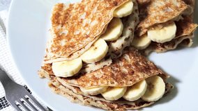 Thin crepes with banana and chocolate on a white plate. - Powered by Shutterstock - Get 15% off with code: PIKWIZARD15