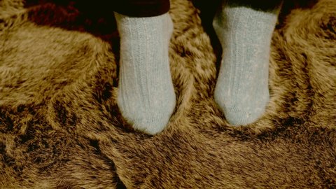 Woman in angora socks enjoys and caresses herself in a sheepskin