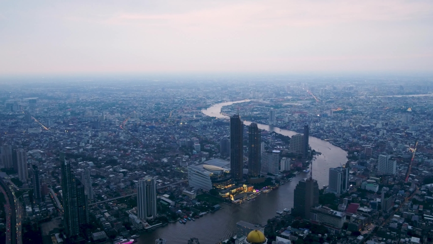 Aerial drone view of the Bangkok View from the river bank side, boat pier and the city skyline with skyscrapers in the background. Royalty-Free Stock Footage #1062105907