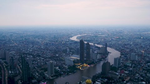 Aerial drone view of the Bangkok View from the river bank side, boat pier and the city skyline with skyscrapers in the background.